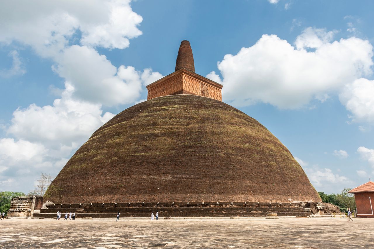 about-us Explore the ancient Abhayagiri Stupa in Anuradhapura under a clear blue sky.
